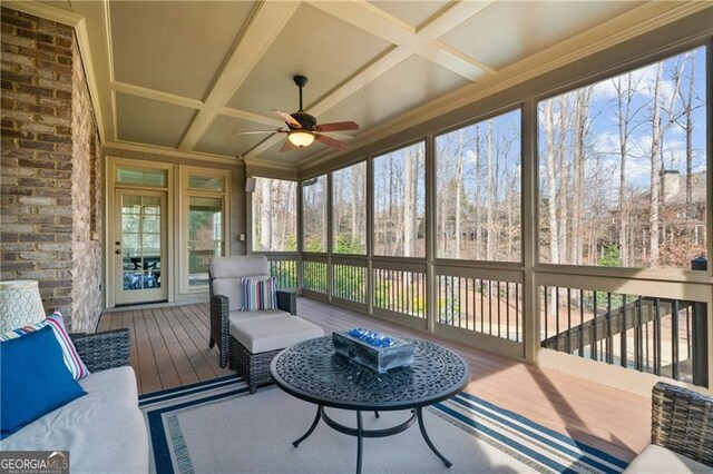sunroom / solarium with a ceiling fan, coffered ceiling, and a wealth of natural light