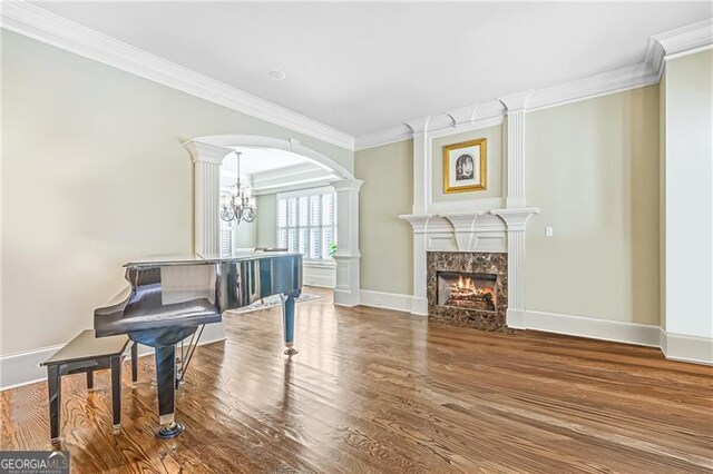 dining room with an inviting chandelier, wainscoting, a raised ceiling, wood finished floors, and ornamental molding