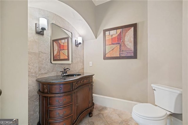 bathroom featuring vanity, baseboards, and toilet