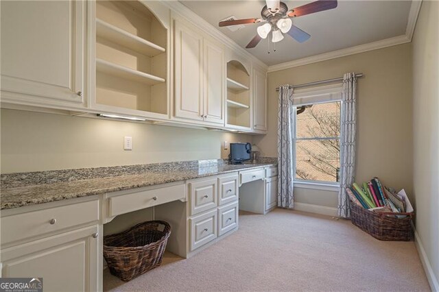 office area with crown molding, ceiling fan, light carpet, and built in study area