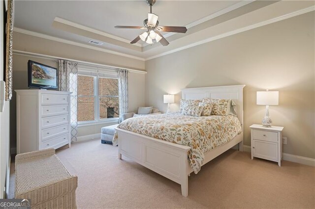 bedroom featuring visible vents, a raised ceiling, crown molding, and light carpet