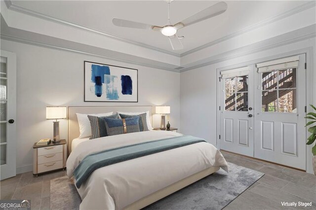 bedroom featuring baseboards, ornamental molding, a ceiling fan, and a tray ceiling