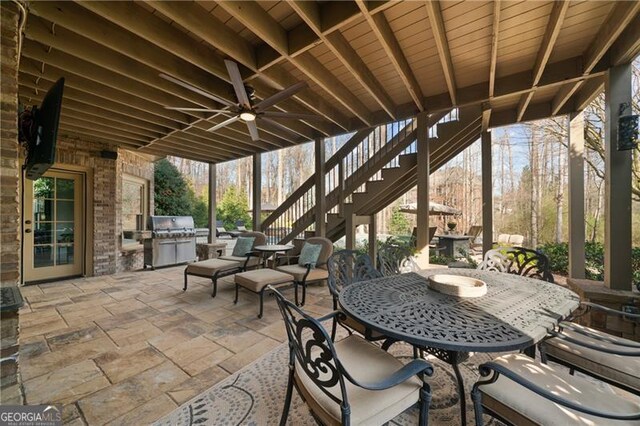 view of patio / terrace with stairs, outdoor dining space, exterior kitchen, ceiling fan, and area for grilling