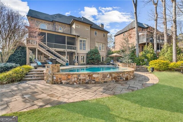 view of swimming pool featuring a sunroom, a patio area, a yard, and stairway