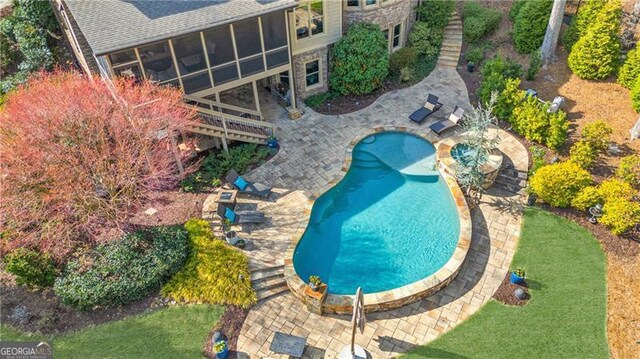 outdoor pool with a patio and a sunroom