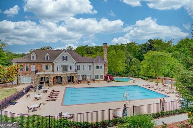 community pool featuring a patio area and fence