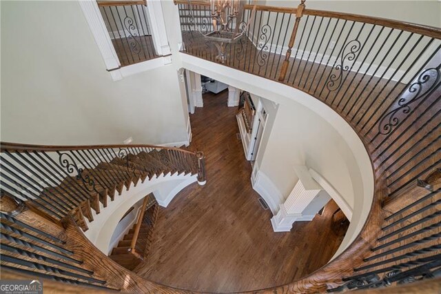 stairs featuring a high ceiling and wood finished floors
