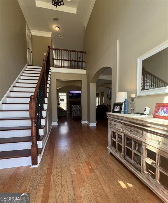 2973 Red Fox Dr, Haddock, GA 31033 - foyer featuring arched walkways, wood-type flooring, stairway, and baseboards
