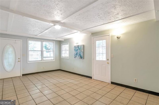 foyer featuring a textured ceiling, light tile patterned floors, and a healthy amount of sunlight