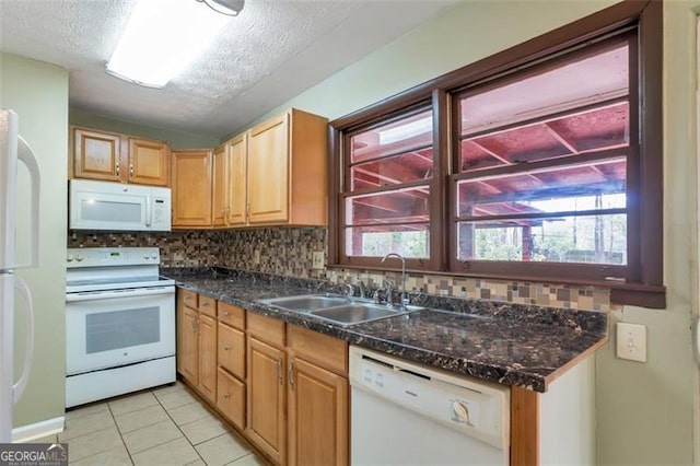 kitchen featuring light tile patterned floors, a sink, white appliances, tasteful backsplash, and a textured ceiling