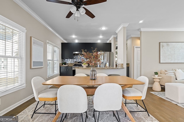 dining room featuring a ceiling fan, baseboards, recessed lighting, ornamental molding, and light wood-type flooring