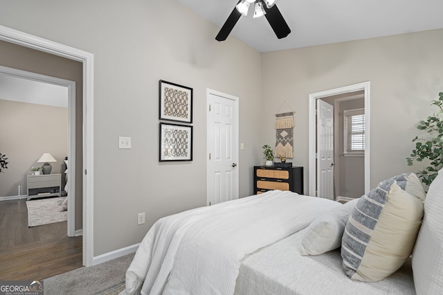 bedroom with vaulted ceiling, wood finished floors, baseboards, and ceiling fan