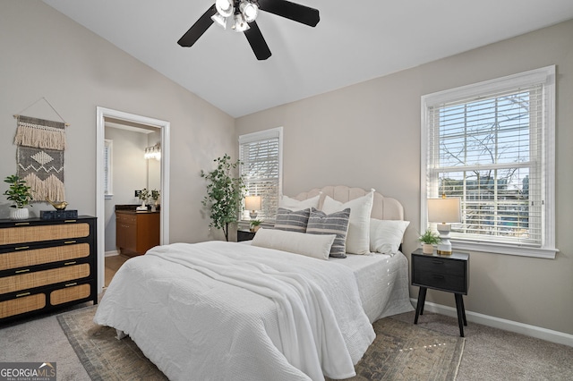 carpeted bedroom featuring vaulted ceiling, a ceiling fan, baseboards, and ensuite bathroom
