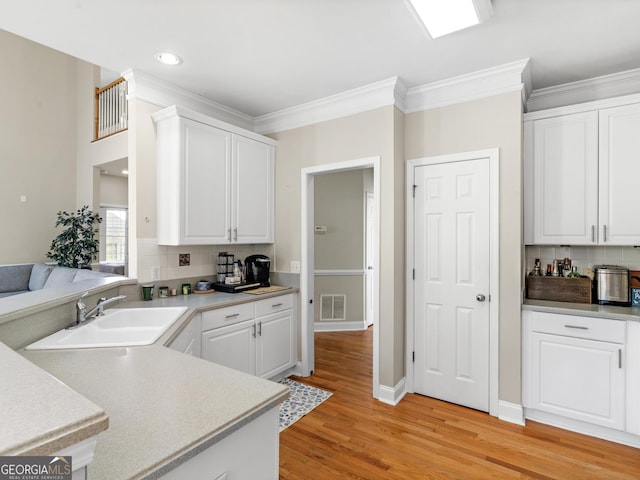 152 Vinings Lake Ct SW, Mableton, GA 30126 - kitchen featuring white cabinetry, a sink, light wood finished floors, and visible vents
