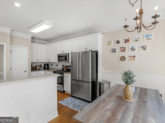 152 Vinings Lake Ct SW, Mableton, GA 30126 - kitchen with white cabinetry, crown molding, stainless steel appliances, and a notable chandelier