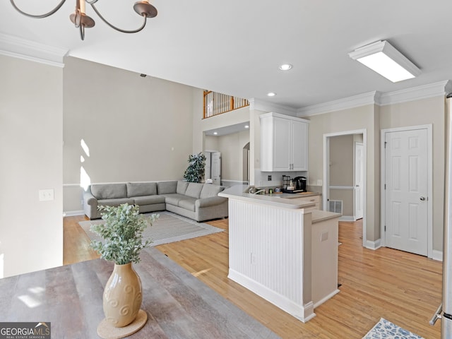 152 Vinings Lake Ct SW, Mableton, GA 30126 - kitchen with white cabinets, ornamental molding, recessed lighting, light wood-type flooring, and a notable chandelier