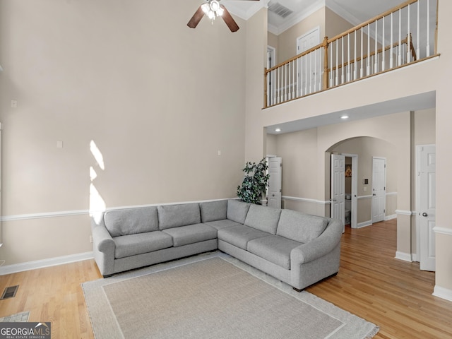 152 Vinings Lake Ct SW, Mableton, GA 30126 - living room featuring light wood-style flooring, visible vents, baseboards, a ceiling fan, and arched walkways