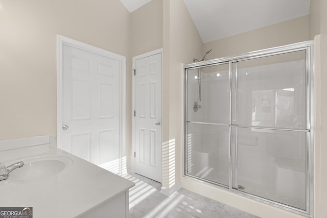 full bathroom featuring two vanities, a shower stall, and a sink