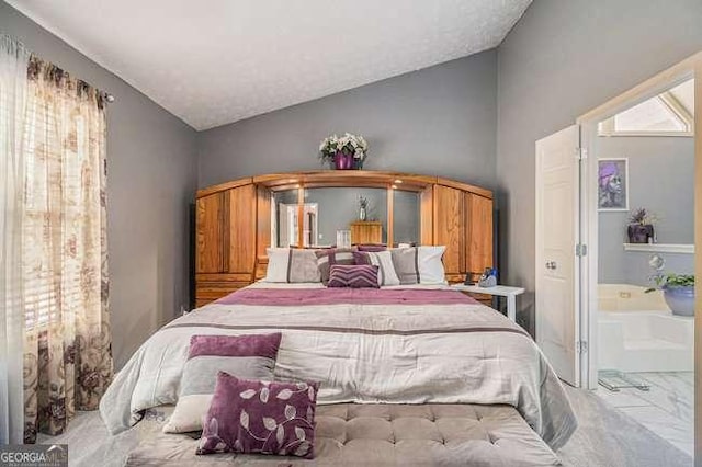 bedroom featuring connected bathroom and vaulted ceiling