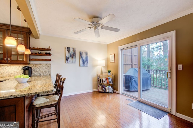 dining space featuring crown molding, ceiling fan, wood-type flooring, baseboards, and visible vents