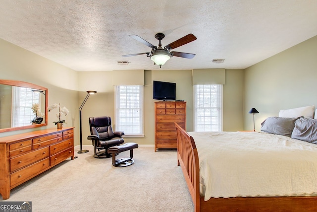 bedroom with multiple windows, visible vents, and a textured ceiling