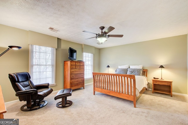 carpeted bedroom with visible vents, a ceiling fan, and baseboards