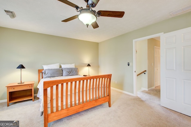 carpeted bedroom featuring baseboards, a ceiling fan, and visible vents
