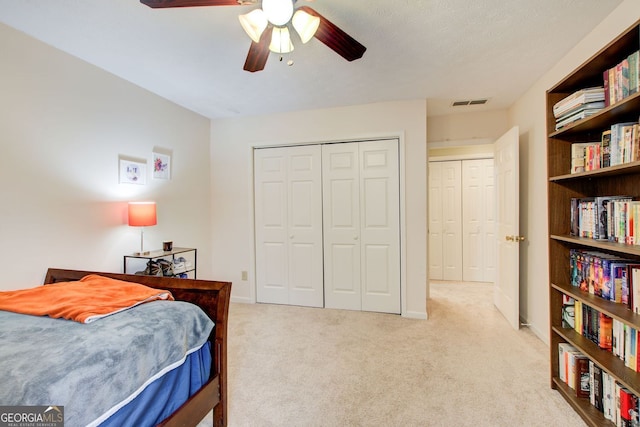 bedroom featuring visible vents, a ceiling fan, light carpet, a closet, and baseboards