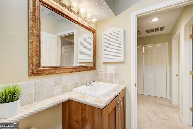 bathroom with vanity, visible vents, and backsplash