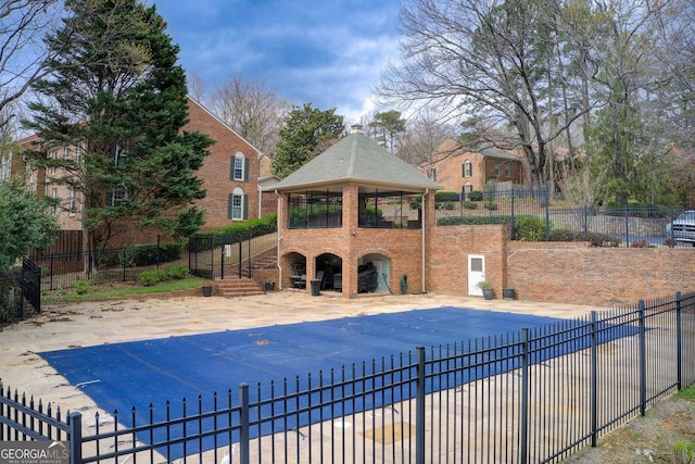 view of pool with fence, a patio area, a fenced in pool, and a gazebo