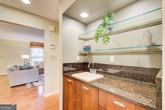 bathroom featuring baseboards, wood finished floors, and vanity