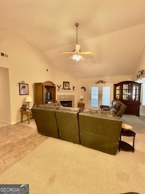 5555 Carlton Ln, Garfield, GA 30425 - living room with a ceiling fan, a tile fireplace, plenty of natural light, light colored carpet, and high vaulted ceiling