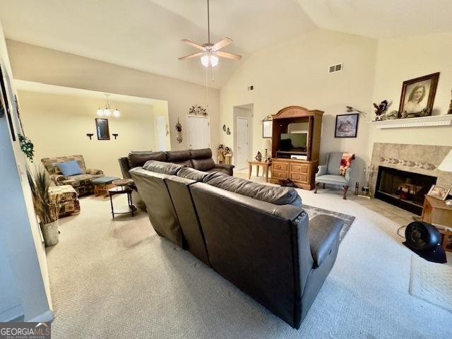 5555 Carlton Ln, Garfield, GA 30425 - living area with carpet floors, a ceiling fan, vaulted ceiling, and a tile fireplace