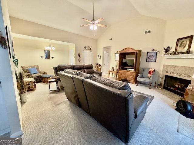 5555 Carlton Ln, Garfield, GA 30425 - living room featuring carpet, a ceiling fan, lofted ceiling, a high end fireplace, and a chandelier