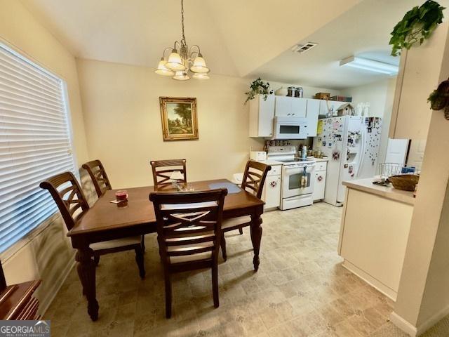 5555 Carlton Ln, Garfield, GA 30425 - dining space with a chandelier, lofted ceiling, and light floors