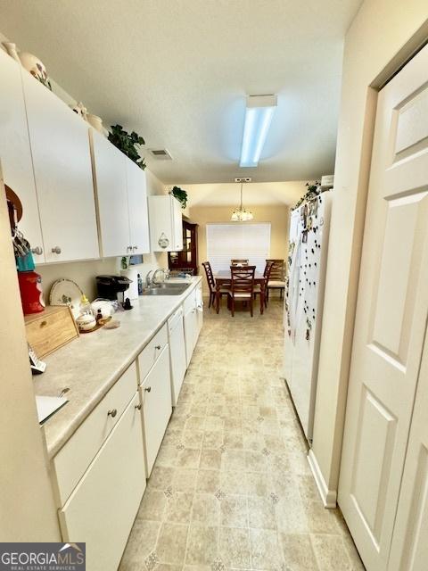 5555 Carlton Ln, Garfield, GA 30425 - kitchen with white appliances, a sink, white cabinets, and light countertops