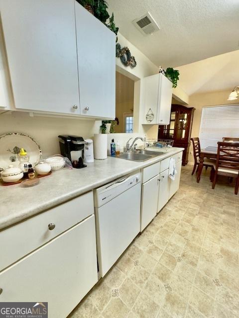 5555 Carlton Ln, Garfield, GA 30425 - kitchen featuring dishwasher, a sink, light countertops, white cabinetry, and lofted ceiling