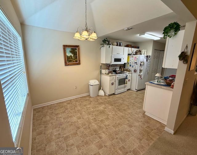 5555 Carlton Ln, Garfield, GA 30425 - kitchen featuring white appliances, a chandelier, baseboards, vaulted ceiling, and light countertops