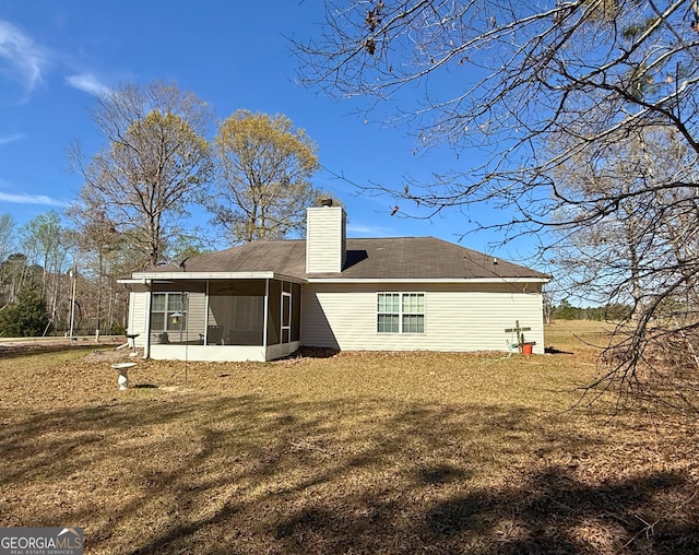 5555 Carlton Ln, Garfield, GA 30425 - rear view of house featuring a sunroom, a chimney, and a yard