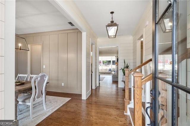 entrance foyer with wood finished floors and a decorative wall