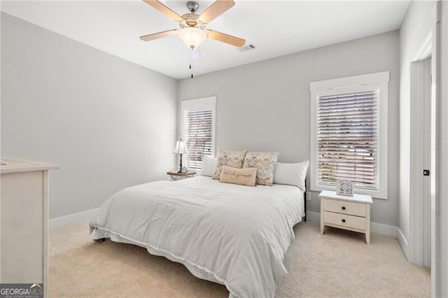 bedroom with light colored carpet, baseboards, and a ceiling fan