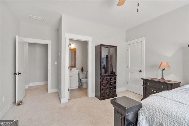 bedroom featuring light carpet, baseboards, ensuite bath, and a ceiling fan