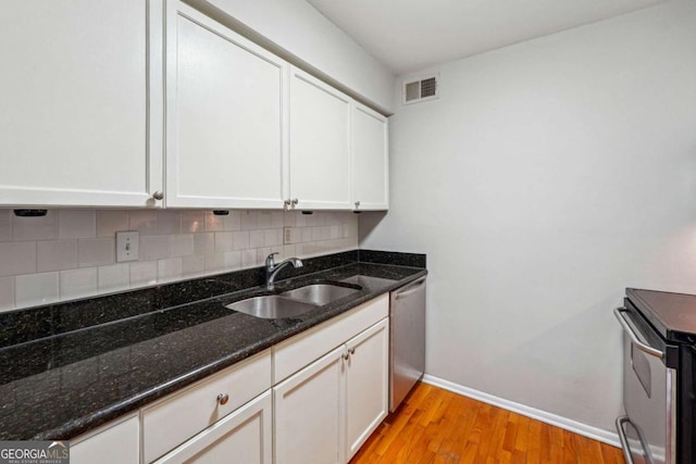 kitchen featuring visible vents, a sink, backsplash, white cabinetry, and stainless steel appliances
