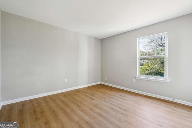 empty room with light wood-type flooring and baseboards