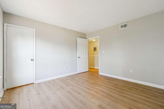 unfurnished bedroom featuring light wood finished floors, visible vents, and baseboards
