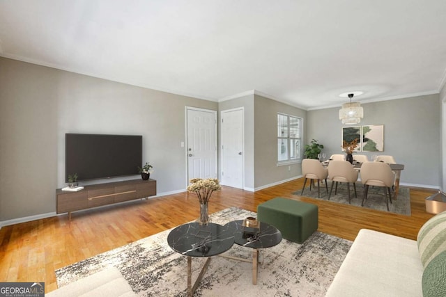 living room featuring wood finished floors, baseboards, and ornamental molding