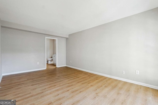 unfurnished room featuring baseboards and wood finished floors
