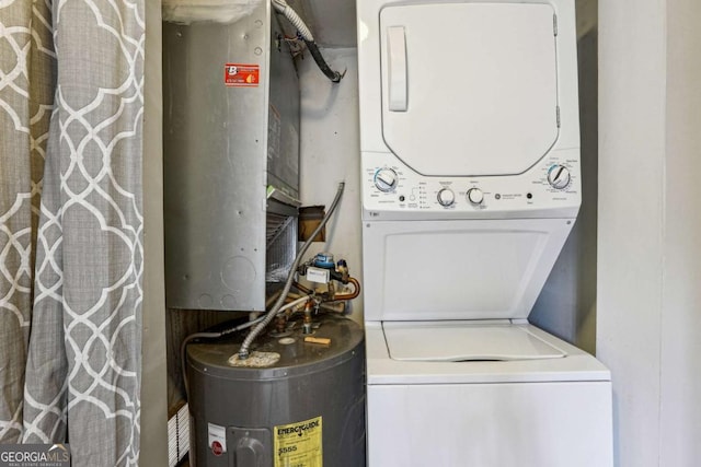 washroom featuring laundry area, stacked washer / dryer, and water heater
