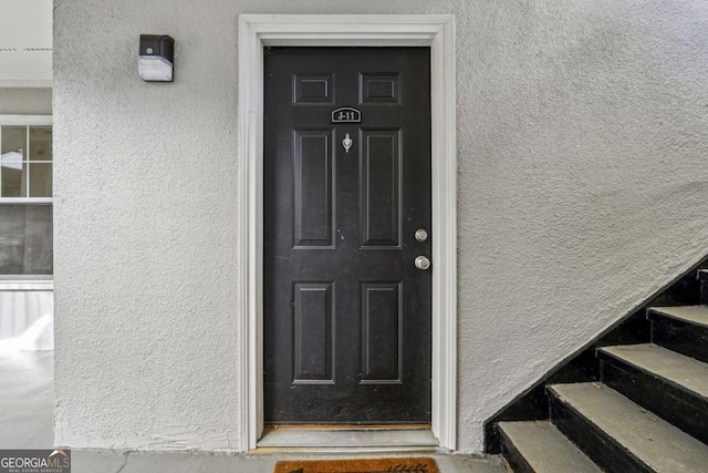 property entrance with stucco siding