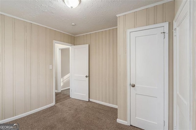 2203 Knoll Dr, Decatur, GA 30032 - unfurnished bedroom with ornamental molding, a textured ceiling, carpet floors, wooden walls, and baseboards